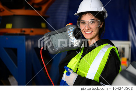 Female maintenance worker with machine robotic arms at industrial factory 104243508
