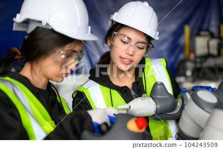 Professional maintenance worker with machine robotic arms at industrial factory 104243509