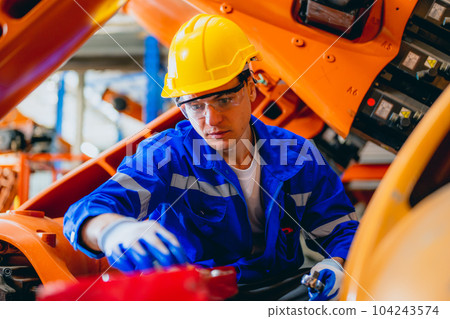 Professional maintenance worker with machine robotic arms at industrial factory Professional maintenance worker with machine robotic arms at industrial factory 104243574