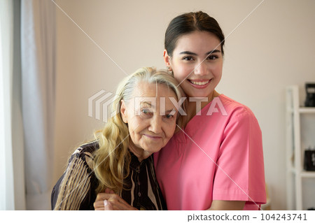Happy caregiver and senior patient smiling and looking at camera Happy caregiver and senior patient smiling and looking at camera 104243741