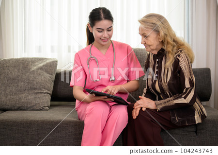 Young doctor or nurse visiting happy senior patient at home 104243743