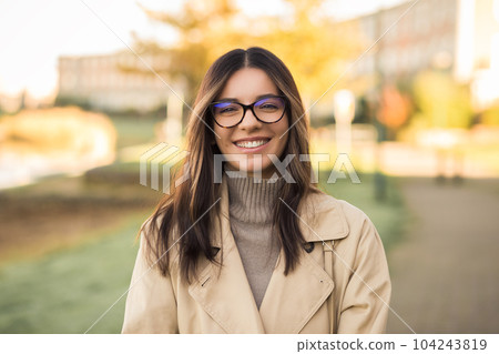 Cheerful LGBT female student wearing glasses joyfully smiling beautifully in front of campus 104243819