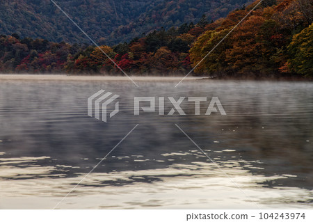 Scenery of autumn leaves in the morning mist on the shore of Lake Chuzenji 104243974