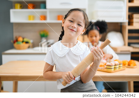 Children making bread in kitchen, Kids learning kitchen skill  104244342