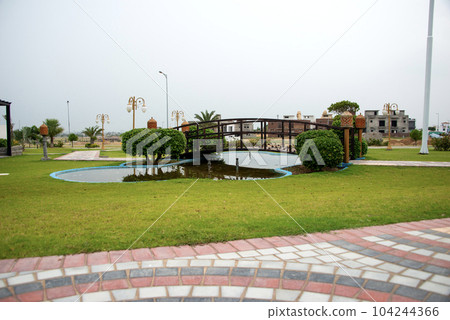 A public park in Kharian City, Pakistan, with a wooden bridge and pathway. 104244366