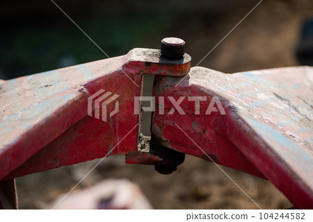 A closeup view of the coupling on a disc harrow for cultivating land 104244582