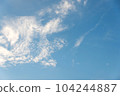 Scattered cloud clusters in a blue sky, blue sky background with white clouds. 104244887