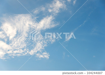 Scattered cloud clusters in a blue sky, blue sky background with white clouds. 104244887