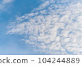 Scattered cloud clusters in a blue sky, blue sky background with white clouds. 104244889