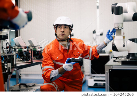 Professional technician holding robot controller checking machine 104245266