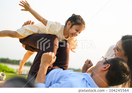 Happy family relaxing and resting in park together on weekend 104245564