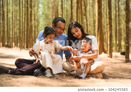 Smiling father and mother spending travel time with children at park 104245565
