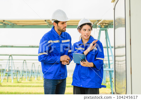 Technicians workers installing solar panels at solar cell farm 104245617