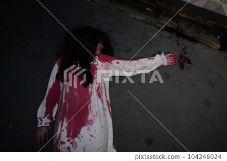 Scary woman in white dress with bloodstain after murder, Halloween concept 104246024