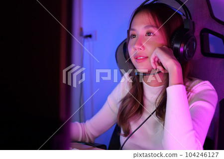 Young female game streamer playing online game on computer at home Young female game streamer playing online game on computer at home 104246127