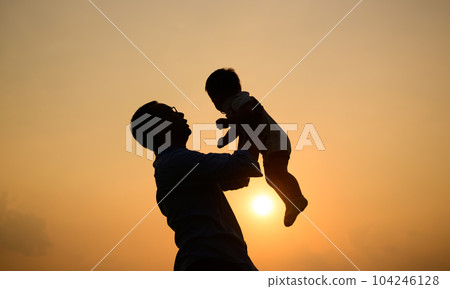 Silhouette shot of happy father holding newborn baby with sunset view Silhouette shot of happy father holding newborn baby with sunset view 104246128