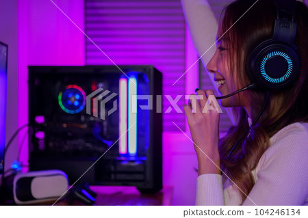 Young woman wearing headphones playing computer game 104246134