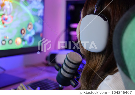 Young female game streamer playing online game on computer at home 104246407