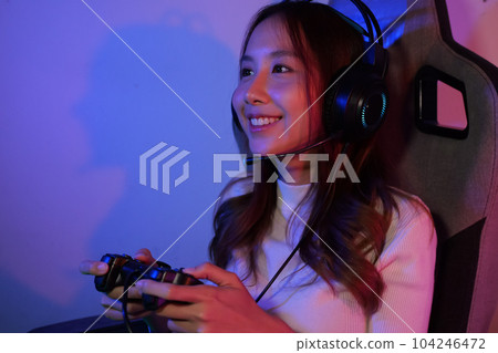 Young female game streamer playing online game on computer at home Young female game streamer playing online game on computer at home 104246472