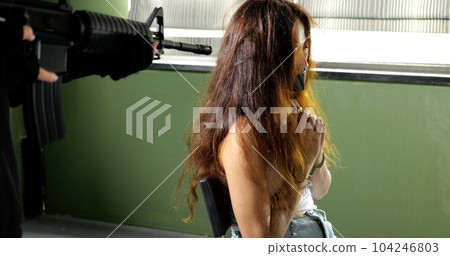 Unknown terrorist or murderer holding gun pointed to the head of unknown victim 104246803