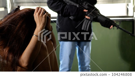 Unknown terrorist or murderer holding gun pointed to the head of unknown victim 104246808
