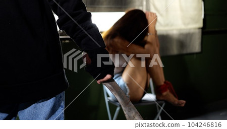 Male murderer holding long knife to threaten unknown female victim 104246816