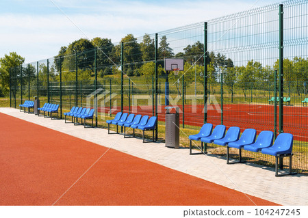 Empty blue plastic chairs in the outdoor sport playground 104247245
