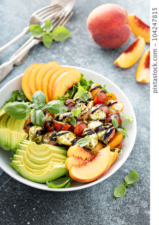 Avocado peach caprese salad with basil pesto 104247815