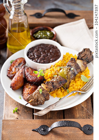 Beef kebab with rice, beans and fried plantains Beef kebab with rice, beans and fried plantains 104247897