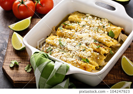 Chicken enchiladas in a casserole dish 104247923