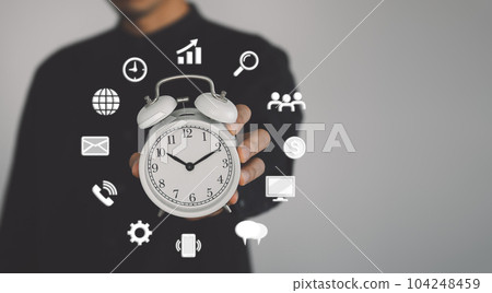 Time managment concept. Business man hold the clock and the icon. Work management. 104248459
