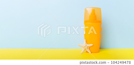 Beach accessories. Moisturiser sunscreen suntan lotion bottle for UVB skincare protection in summer with seashells on colored background. Mock up with copy space Beach accessories. Moisturiser sunscreen suntan lotion bottle for UVB skincare protection in summer with seashells on colored background. Mock up with copy space 104249478
