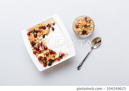 Healthy breakfast food with granola, yogurt, fruits and nuts. Dessert parfait with dried fruits for breakfast 104249625