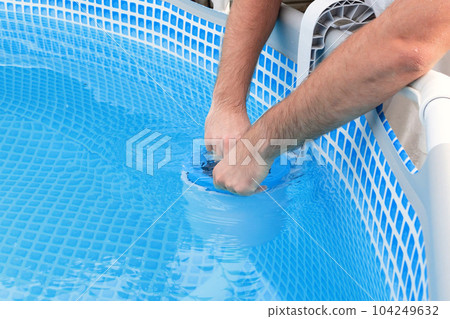 Man cleans skimmer for the frame pool. Contaminated pool cleaning concept 104249632