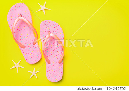 Flat lay composition with flip flops and seashell on colored background. Space for text top view Flat lay composition with flip flops and seashell on colored background. Space for text top view 104249702