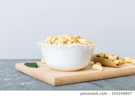 cashew nuts in wooden bowl on table background. top view. Space for text Healthy food cashew nuts in wooden bowl on table background. top view. Space for text Healthy food 104249807