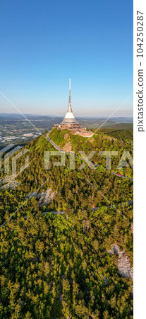 Sunny evening at Jested Mountain with unique building on the summit. Liberec, Czech Republic. Aerial view from drone. 104250287