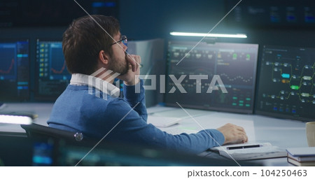 Software engineer sits in front of computer with blockchain network 104250463