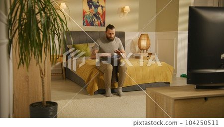 Man sits on bed and plays on traditional djembe Man sits on bed and plays on traditional djembe 104250511
