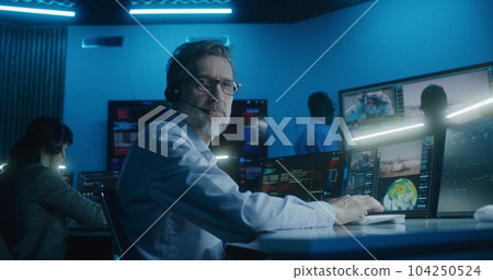 Flight control employee in headset looks at camera 104250524