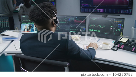 African American trader analyzes market charts 104250792