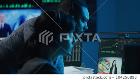 Multracial financial analysts work in bank office in late evening 104250898