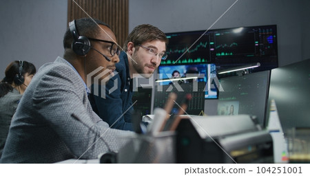 Mixed race stock traders talk and monitor real-time stocks data 104251001