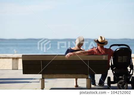 senior couple sitting on a bench looking at the sea senior couple sitting on a bench looking at the sea 104252002