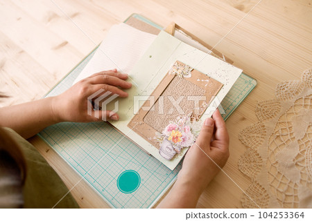 A creative person makes a scrapbook or notebook in their office. Handmade, exclusive. High quality photo A creative person makes a scrapbook or notebook in their office. Handmade, exclusive. High quality photo 104253364