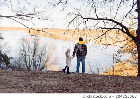 Happy Father's Day concept: Father and daughter standing on a meadow spring background near the river . High quality photo 104253568
