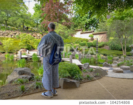 Guide (man) in Japanese garden of Kaiserslautern in geta and kimono Guide (man) in Japanese garden of Kaiserslautern in geta and kimono 104254808