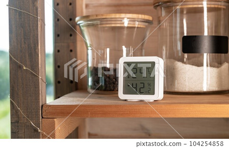 Device for temperature and air humidity control, measurement. Gadget on shelf at home Device for temperature and air humidity control, measurement. Gadget on shelf at home 104254858