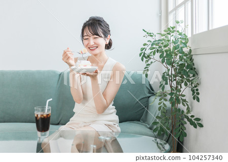 A woman who eats a snack / snack cake at home A woman who eats a snack / snack cake at home 104257340