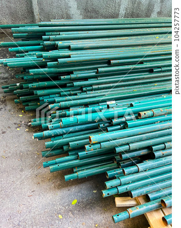 turquoise pipes stacked on the ground. High quality photo turquoise pipes stacked on the ground. High quality photo 104257773